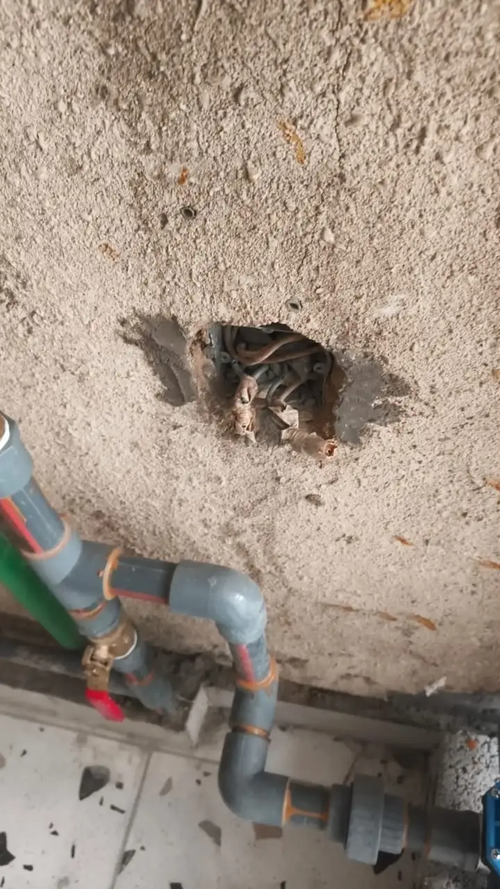 Plumber repairing a hidden water pipe leak inside a wall in Riyadh